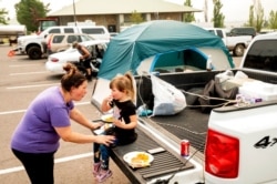 Jackie Armstrong, a Chester resident evacuated from the Dixie Fire, speaks with daughter Zoey Armstrong, 3, at a Susanville, Calif., evacuation shelter, Aug. 6, 2021.