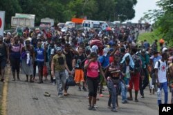 Migrants walk down Highway 200 en route to Huixtla near Tapachula, Chiapas state, Mexico, Oct. 12, 2019. Migrants from Africa, Cuba, Haiti, and other Central American countries set off by foot for the United States.