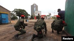 Congolese security officers position themselves as they secure the street near the state television headquarters in the capital Kinshasa, DRC, Dec. 30, 2013.