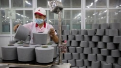 FILE - A worker packages cotton at a Huafu Fashion plant, as seen during a government organized trip for foreign journalists, in Aksu in western China's Xinjiang Uyghur Autonomous Region, April 20, 2021.