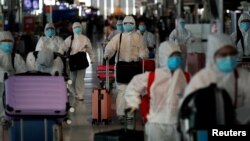 Chinese students living in Thailand wear protective suits as a measure of protection against the coronavirus disease (COVID-19) as they walk at the Suvarnabhumi Airport before boarding a repatriation flight, in Bangkok, Thailand April 21, 2020.