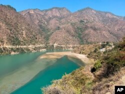 Rescuers leave on a boat to search for bodies in the downstream of Alaknanda River in Rudraprayag, northern state of Uttarakhand, India, Feb.8, 2021.