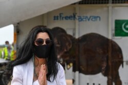 Pop singer Cher gestures in front of the crate of Kaavan the Asian elephant upon his arrival in Cambodia from Pakistan at Siem Reap International Airport in Siem Reap, Nov. 30, 2020.
