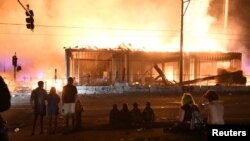 Manifestantes se reunieron cerca del tercer precinto policial en Minneapolis, Minnesota, EE.UU., para observar el incendio de un sitio después que un policía blanco fue visto en un video presionando el cuello de George Floyd, un afroamericano.