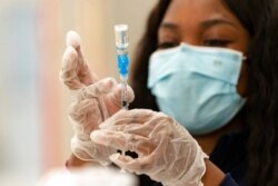 Seorang pekerja Kesehatan menyiapkan vaksin COVID-19 buatan Johnson & Johnson untuk vaksinasi kepada warga di Baldwin Hills Crenshaw Plaza di Los Angeles, California, 11 Maret 2021.