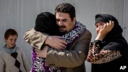 Balkis, 15, embraces her father, Sheikh Matar, March 31, 2016. after being separated from him for over a year. Balkis stayed with her mother, younger sister, and two younger brothers in Islamic State group-controlled territory after her father was forced to the Kurdish north.