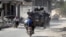 FILE - Men ride motorbikes past a Turkish armored carrier in the northern Syrian rebel-held town of al-Rai, in Aleppo Governorate, Syria, Oct. 5, 2016.
