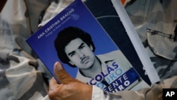 Un asistente al estreno de una película biográfica del presidente Nicolás Maduro sostiene un folleto informativo de la obra, donde se ve al mandatario cuando era joven, en Caracas, este 14 de julio de 2024.