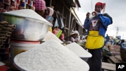 Une vendeuse emballe une portion de riz pour un client au marché d'Agbogboloshie à Accra, au Ghana, vendredi 6 juin 2008. 