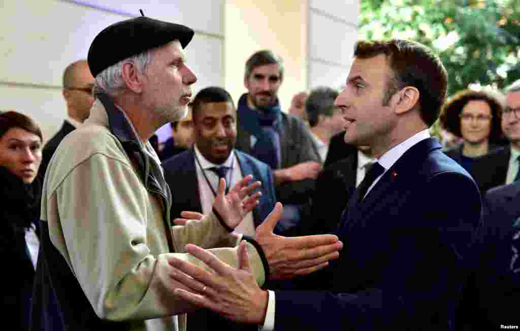 French mathematics teacher Pierre Coste speaks with President Emmanuel Macron about the government&#39;s pensions overhaul at the Beaumont Palace in Pau.