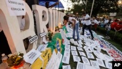 Friends and relatives light candles during a march paying homage to the victims of a mining dam collapse a week ago, in Brumadinho, Brazil, Feb. 1, 2019. 