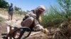 FILE - A de-miner searches for mines in Bagram, north of Kabul, Afghanistan, June 10, 2009.