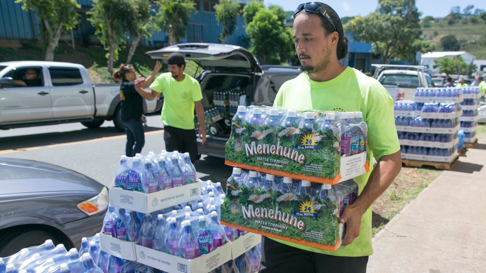 FILE - A worker at the Hawaiian water company carries bottle of water to customers hoping to stockpile water before a 2014 tropical storm.