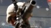 FILE - A U.S. Army soldier is seen in front of a bullet-riddled truck in the Pesh Valley in Afghanistan's Kunar Province, Aug 4, 2009. The U.S. military is investigating a video that appears to show an American service member firing into the cab of a civilian truck in Afghanistan.