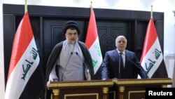 Le chef chiite irakien Moqtada al-Sadr et le Premier ministre irakien Haider al-Abadi s'expriment lors d'une conference à Bagdad, Irak, le 20 mai 2018