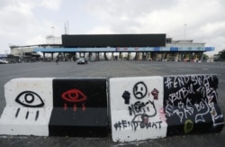 A roadblock with graffiti is seen at the Lekki toll gate, site of protests that turned deadly when security forces opened fire on demonstrators earlier this week, in Lagos, Nigeria, Oct. 24, 2020.