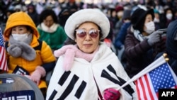 Para pendukung Presiden Korea Selatan Yoon Suk Yeol menghadiri pawai di dekat gedung Mahkamah Konstitusi di Seoul, Kamis, 23 Januari 2025, setelah Yoon tiba untuk persidangan. (Foto: Anthony Wallace/AFP)