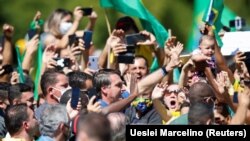 Brazil's President Jair Bolsonaro reacts during a meeting with supporters protesting in his favor, amid the coronavirus disease (COVID-19) outbreak.