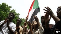 Scores of students of a Khartoum-based university celebrate after an agreement was reached between protest leaders and members of the Transitional Military Council in the Sudanese capital, July 17, 2019. 