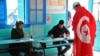 Un électeur tunisien drapé du drapeau national dans un bureau de vote à La Marsa, dans la banlieue de Tunis, le 21 décembre 2014.