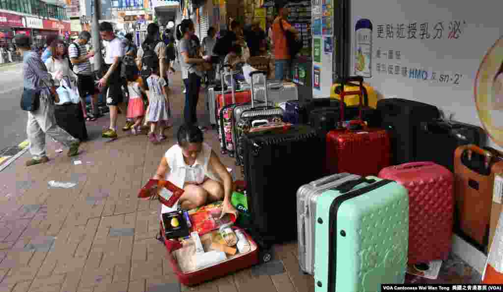 上水街頭隨處可見店舖外堆滿中國遊客及水貨客的「行李箱陣」 (美國之音湯惠芸)