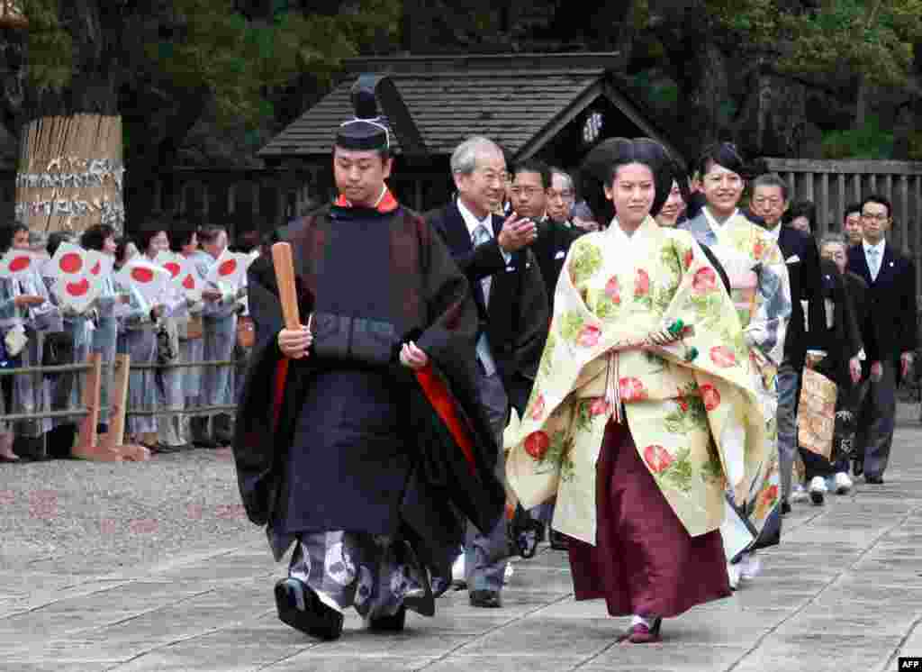 Japans Princess Noriko (R), second daughter of the late Prince Takamado dressed in an ancient Japanese formal court and Kunimaro Senge (L), the eldest son of the chief priest of the Izumo grand shrine walk with their family members for wedding procession at the Izumo grand shrine in Izumo city in Shimane prefecture, western Japan. 