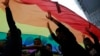 资料照片：在香港一年一度的同志骄傲游行中，参与者举起象征同性恋权利运动的彩虹旗。（2017年11月25日）。2023年10月24日，香港一家法院维持了支持给予同性伴侣平等继承权的裁决，这是香港LGBTQ+群体的一次胜利。