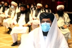 A member of Taliban negotiation delegation keeps his face mask on during the opening session of the peace talks between the Afghan government and the Taliban in Doha, Qatar, Sept. 12, 2020.