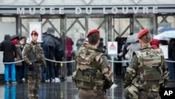French soldiers patrol in the courtyard of the Louvre museum with the visitor control in background in Paris, Feb. 4, 2017. The Louvre in Paris reopened to the public Saturday morning, less than 24-hours after a knife-wielding assailant reportedly shouting "Allahu Akbar!" was shot by soldiers, in what officials described as a suspected terror attack.