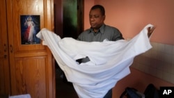 FILE - Catholic priest Jean-Nicaisse Milien changes clothes before a Mass in Port-au-Prince, Haiti, Nov. 7, 2021. Father Milien was kidnapped for 20 days along with other priests, nuns, and civilians in April by the 400 Mawozo gang.