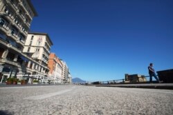 A man walks along Naples promenade, Italy, April 27, 2020.