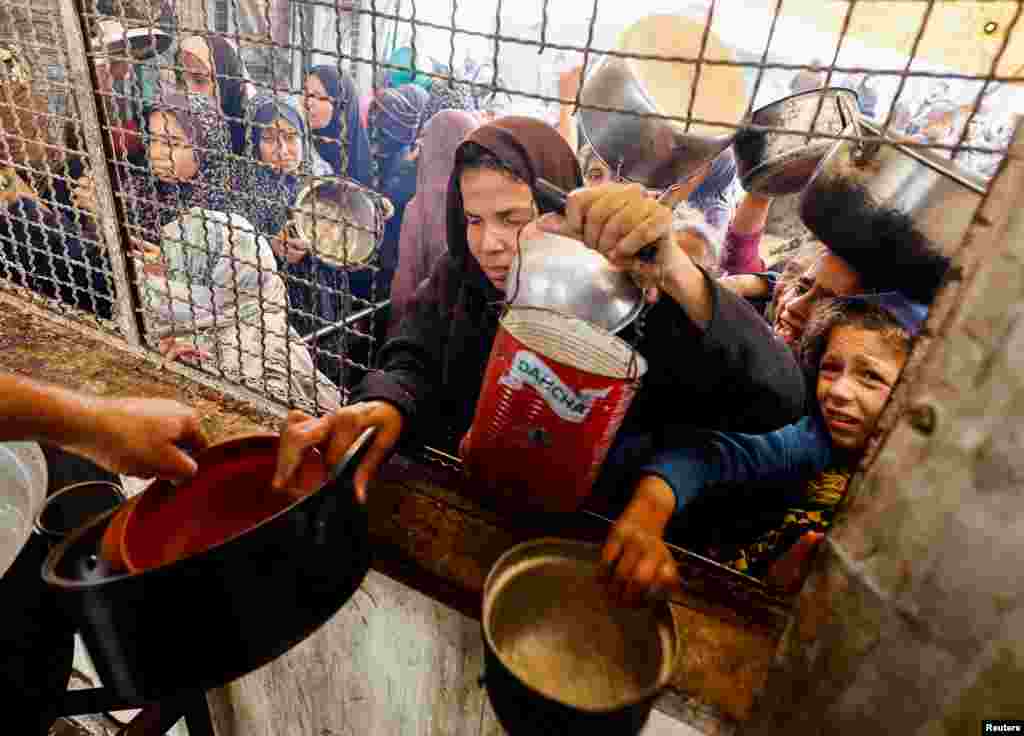 Palestinians stitchery  to person   nutrient  cooked by a foundation  kitchen, amid a hunger crisis, arsenic  the Israel-Hamas struggle  continues, successful  Khan Younis, confederate  Gaza Strip.