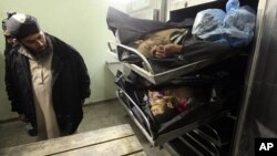 A man looks at the bodies of two Palestinians who were killed by Israeli troops in the northern Gaza Strip, 6 Jan 2010