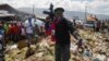 FILE - Jimmy Cherizier, also known as Barbecue, the leader of the "G9 and Family" gang, stands next to a garbage pile to call attention to the conditions people live in as he leads a march against kidnapping through La Saline neighborhood in Port-au-Prince, on October 22, 2021. 