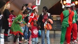 Flight attendant Dre Zulaica, front left, greets a participant and her guardian during the United Airlines annual "fantasy flight" to a fictional North Pole at Denver International Airport, in Denver, Colorado, Dec. 14, 2024.