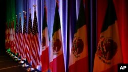 Las banderas de Canadá, Estados Unidos y México son iluminadas durante una conferencia de prensa en el inicio de las negociaciones sobre el TLCAN en Washington el 16 de agosto de 2017.