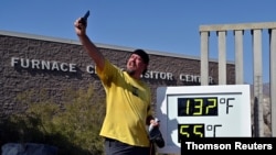 Un hombre se hace una foto frente a un termómetro en el Valle de la Muerte, en California, el 17 de agosto de 2020.