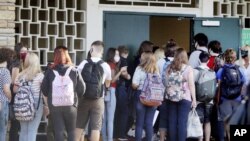 FILE - Students enter Gulf Middle School during the first day of school for Pasco County Schools in New Port Richey, Fla., in this Monday, Aug. 24, 2020, file photo. The U.S. has seen a string of COVID-19 outbreaks tied to summer camps in recent weeks in 