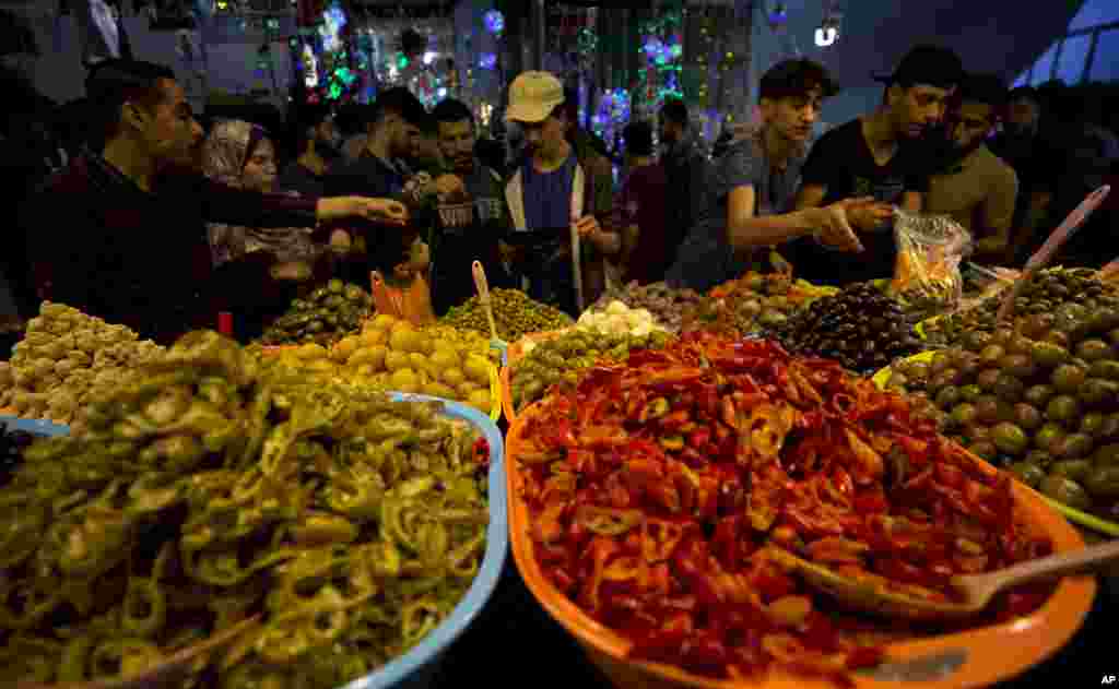 Warga Palestina memperhatikan berbagai penganan acar yang dijual pada Ramadan di sebuah pasar di Kota Gaza, 7 Mei 2019. (Foto: Hatem Moussa/AP)