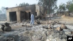 A man walks past burnt out houses following an attack by Boko Haram in Dalori village 5 kilometers (3 miles) from Maiduguri, Nigeria, Jan. 31, 2016.