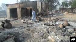 A man walks past burnt out houses following an attack by Boko Haram in Dalori village 5 kilometers (3 miles) from Maiduguri, Nigeria, Jan. 31, 2016.