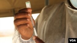 FILE - A Zimbabwe health official prepares to vaccinate a citizen on November 16, 2021 at Wilkins Hospital in Harare.