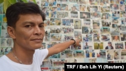 Chairat Ratchapaksi, who founded the Thai and Migrant Fishers Union Group to help trafficked fishermen like him, poses for a photo in front of pictures of rescued trafficking victims in Samut Sakhon, Thailand, March 25, 2018.