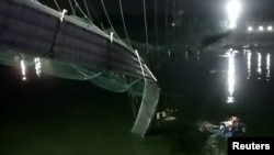 A view shows a damaged part of a suspension bridge after it collapsed in Morbi