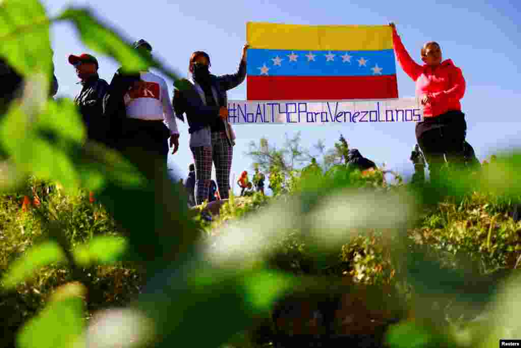 Migrantes venezolanos, algunos expulsados de EEUU a México bajo el Título 42 y otros que aún no han cruzado tras las nuevas políticas migratorias, muestran un cartel que dice &quot;No al Título 42 para venezolanos&quot;, a orillas del Río Bravo, en Ciudad Juárez, México, el 26 de octubre de 2022. REUTERS/José Luis González&nbsp;&nbsp;