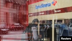 FILE - A customer uses an ATM at a Bank of America branch in Boston, Massachusetts, U.S.