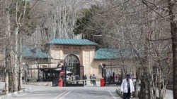 2026年3月22日，一名行人走在伊朗德黑兰的街道上，背景是历史悠久的戈勒斯坦宫。