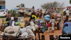 FILE - Chadian cart owners transport belongings of Sudanese people who fled the conflict in Sudan's Darfur region, while crossing the border between Sudan and Chad in Adre, Chad August 4, 2023. 