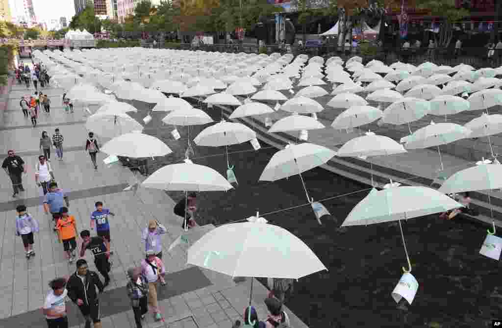 Visitors walk under the umbrellas on display over Cheonggye stream during a campaign to raise money to help underprivileged children in Seoul, South Korea.