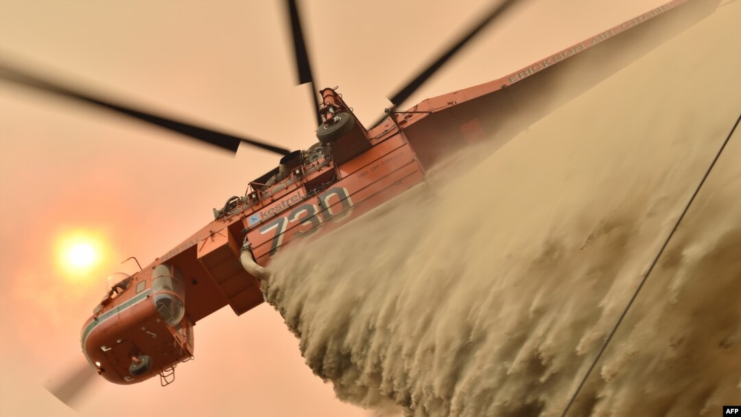 A helicopter drops fire retardent to protect a property in Balmoral, 150 km southwest of Sydney on Dec. 19, 2019. 